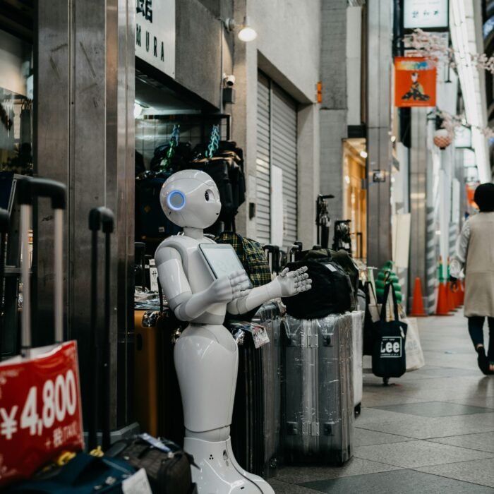 A bot is standing outside a shop holding a board.