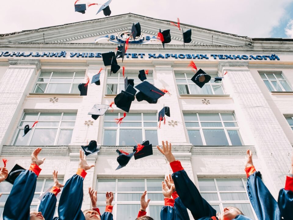 Group of fresh graduates throwing their academic hats in the air